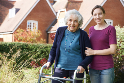 caregiver and a senior woman outside the house