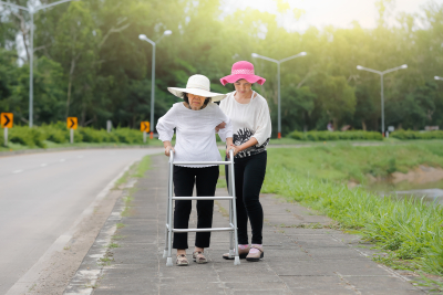 young woman helping a senior woman to walk
